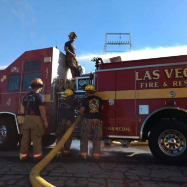 Firefighters attaching hose to truck