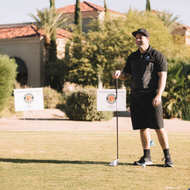 Teriyaki Madness Hole Sponor sign behind him