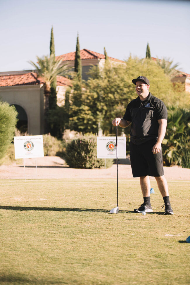 Teriyaki Madness Hole Sponor sign behind him