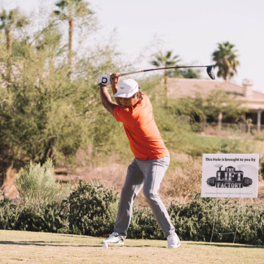 Man swinging with The Lift Factory Hole Sponsor behind him