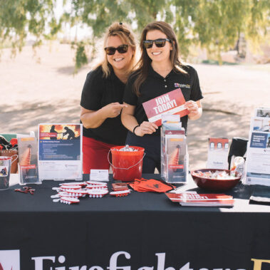 Two girls working the Firefighters First Credit Union booth