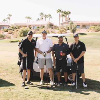 Guys taking a picture in front of the golf cart