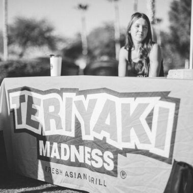 Teriyaki Madness Fresh Asian Grill booth with lady sitting behind the table in black and white