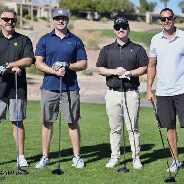 4 golfers posing for a photo on the golf course.