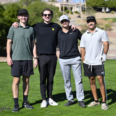 4 golfers posing for a photo on the golf course.