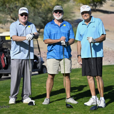 3 golfers posing for a photo on the golf course.