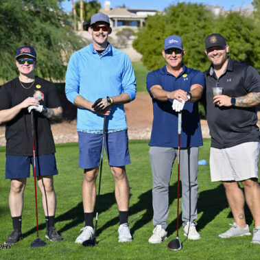 4 golfers posing for a photo on the golf course.