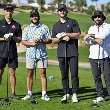 4 golfers posing for a photo on the golf course.