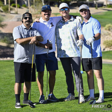 4 golfers posing for a photo on the golf course.