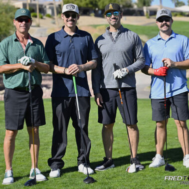 4 golfers posing for a photo on the golf course.