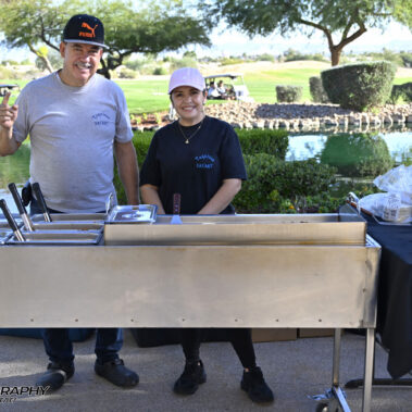 Worker behind buffet table.