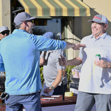 Male golfer raffle winner laughing with friend.