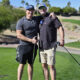 Two male golfer posing for a picture on golf course.