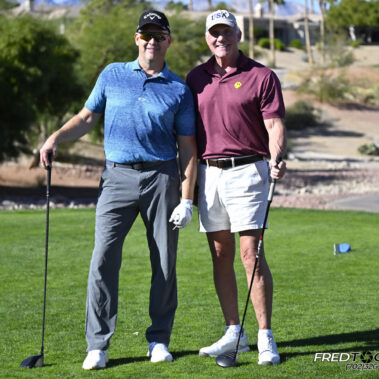 Two male golfer posing for a picture on golf course.