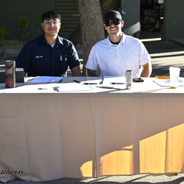 Two male volunteer sitting at a table.