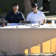 Two male volunteer sitting at a table.